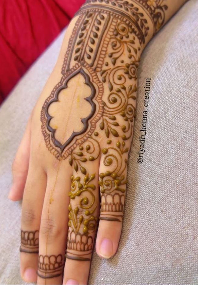 Detailed bridal henna design on back of hand